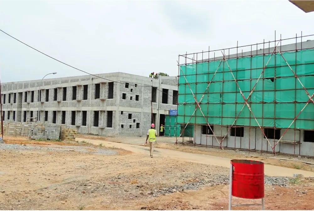 Chantier d'équipement public en structure béton avec échafaudages au Gabon